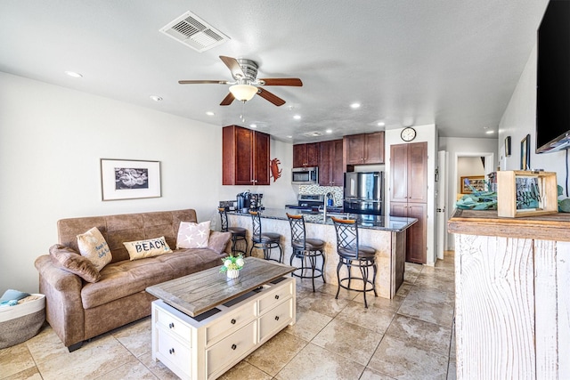 tiled living room with ceiling fan