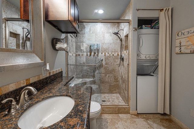 9520 Seawall Blvd Unit 354, Galveston, TX 77554 - full bathroom with stacked washer / drying machine, a shower stall, toilet, vanity, and baseboards