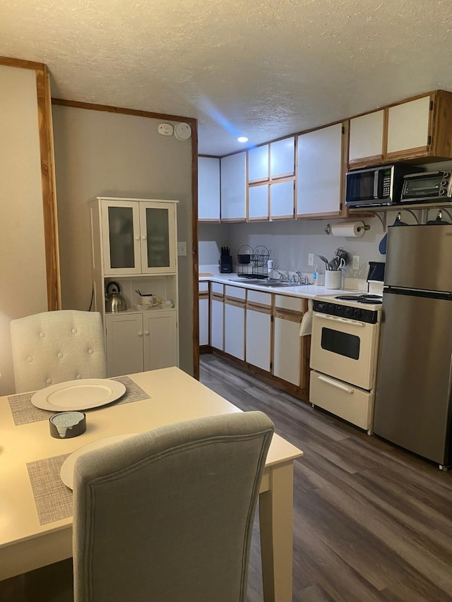 kitchen featuring white cabinets, dark wood-type flooring, a textured ceiling, and appliances with stainless steel finishes