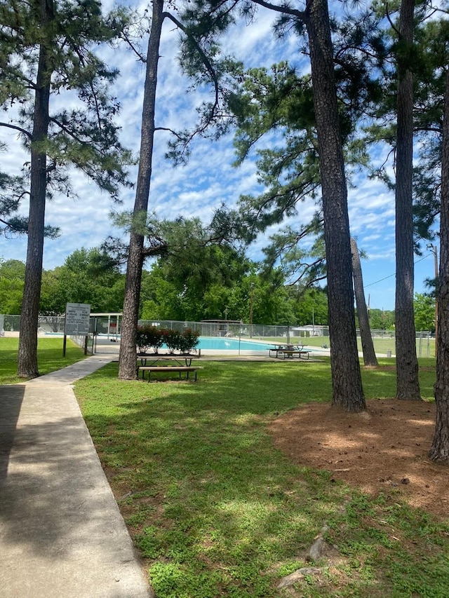 view of property's community with a yard and a swimming pool