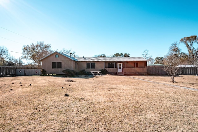 rear view of property featuring a lawn