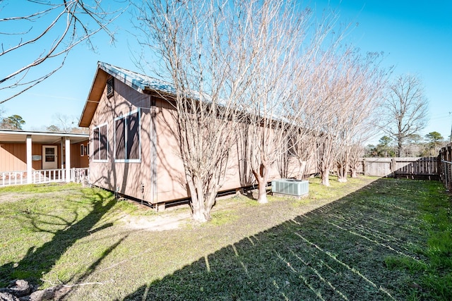 view of property exterior featuring central AC and a lawn