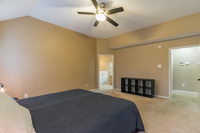 carpeted bedroom featuring ceiling fan, ensuite bathroom, and vaulted ceiling