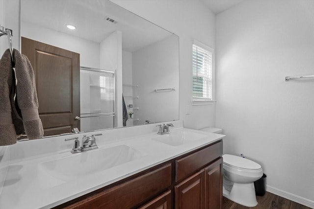 bathroom with vanity, hardwood / wood-style floors, an enclosed shower, and toilet