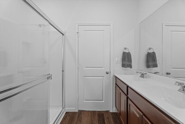 bathroom with vanity, wood-type flooring, and a shower with door