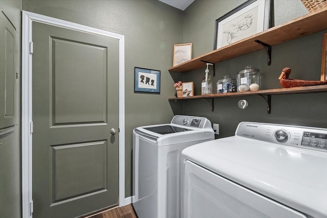 clothes washing area featuring dark hardwood / wood-style floors and washer and clothes dryer