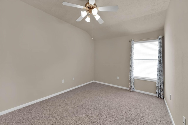 spare room with lofted ceiling, a textured ceiling, ceiling fan, and carpet