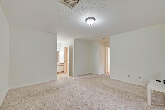 carpeted spare room featuring a textured ceiling