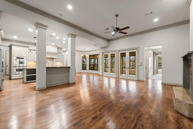 unfurnished living room with light hardwood / wood-style flooring, ornamental molding, decorative columns, and ceiling fan