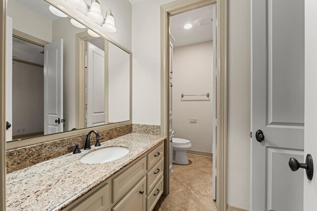 bathroom featuring vanity, tile patterned floors, and toilet