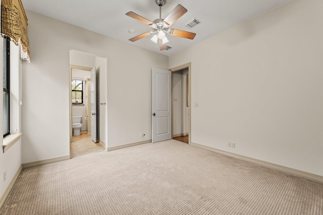 unfurnished bedroom with connected bathroom, light carpet, and ceiling fan