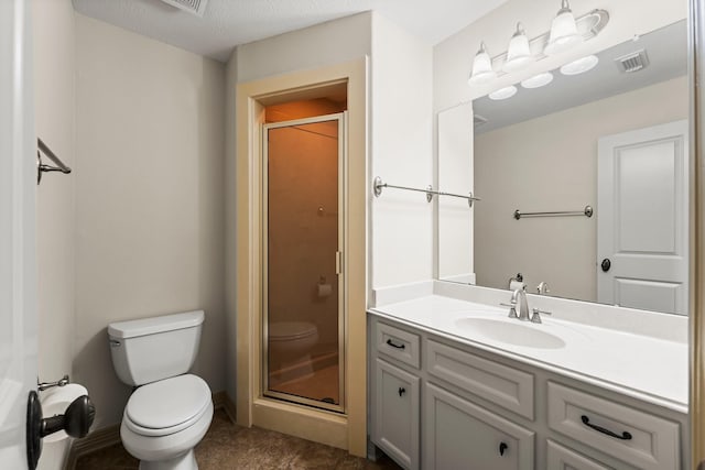 bathroom with vanity, a textured ceiling, a shower with shower door, and toilet