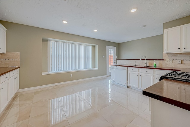 kitchen with sink, a textured ceiling, white cabinets, and white dishwasher