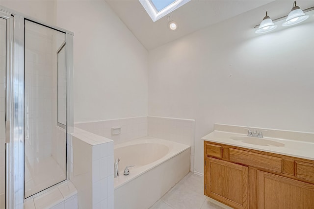 bathroom featuring tile patterned flooring, vanity, vaulted ceiling with skylight, and separate shower and tub