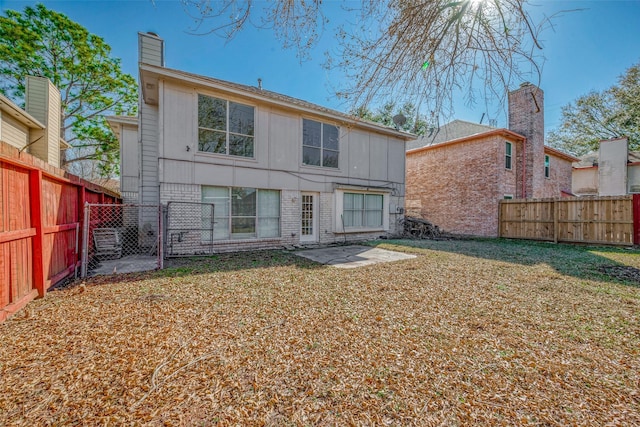 rear view of house with a patio and a lawn