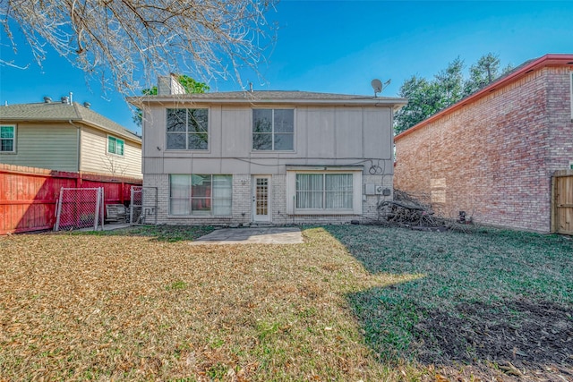 rear view of property with a lawn and a patio