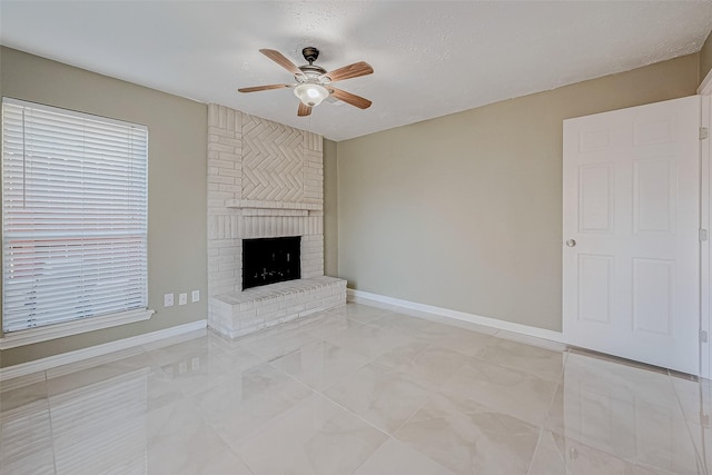 unfurnished living room with a brick fireplace, a textured ceiling, and ceiling fan