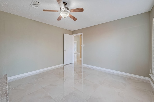 spare room with ceiling fan and a textured ceiling