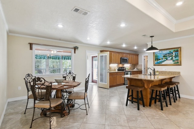 dining space featuring ornamental molding, sink, and light tile patterned floors