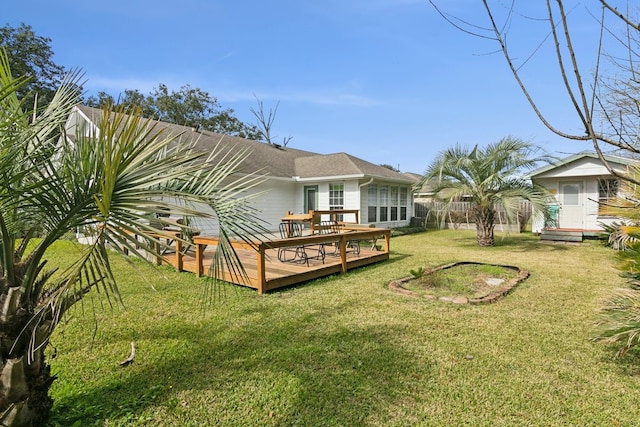 back of property featuring a wooden deck, a storage shed, and a lawn