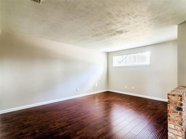 unfurnished room featuring dark hardwood / wood-style floors and a textured ceiling