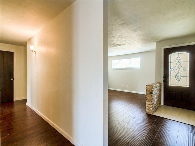 entryway with a textured ceiling and dark hardwood / wood-style flooring