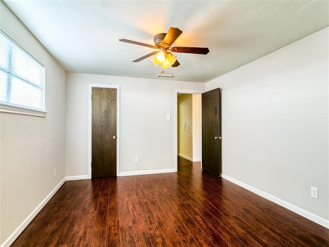 empty room featuring dark wood-type flooring and ceiling fan