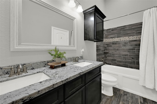 full bathroom featuring wood finished floors, a sink, toilet, and shower / bathtub combination with curtain