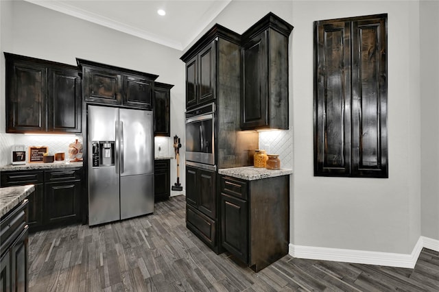 kitchen with baseboards, dark wood-type flooring, light stone countertops, stainless steel appliances, and crown molding