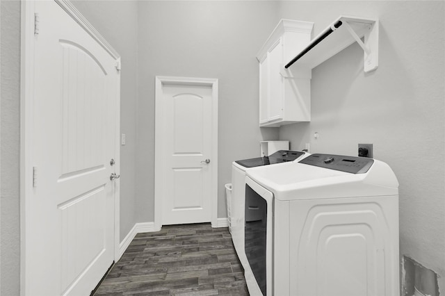 washroom featuring washer and dryer, dark wood-style flooring, cabinet space, and baseboards