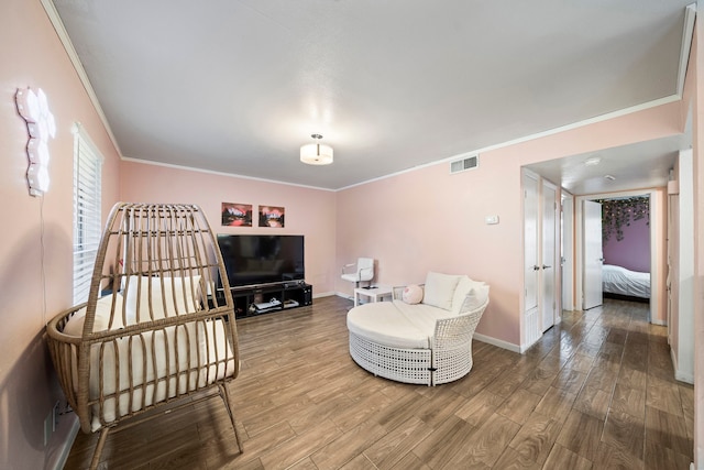 sitting room with hardwood / wood-style flooring and crown molding