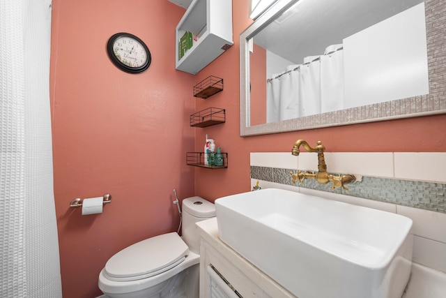 bathroom with vanity, toilet, and decorative backsplash