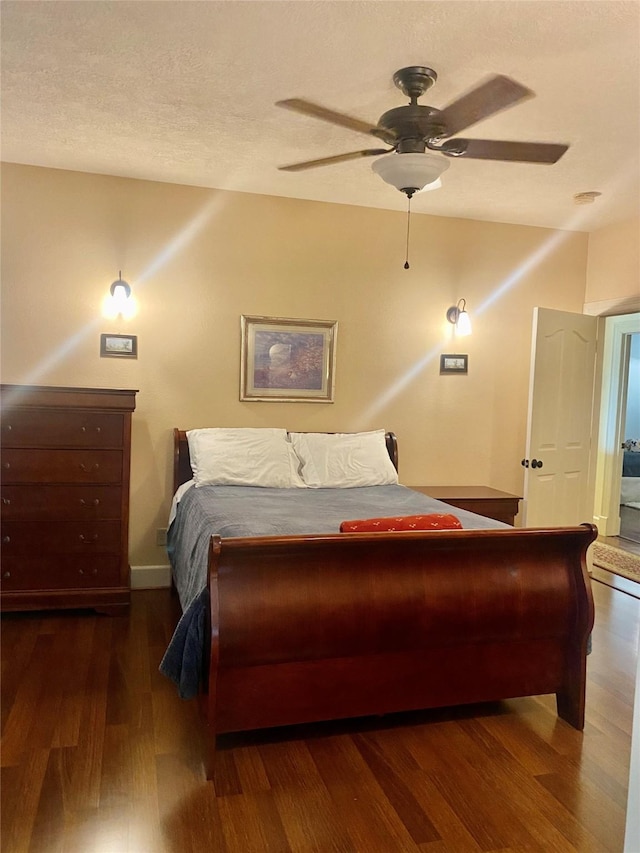 bedroom featuring a textured ceiling, dark wood-type flooring, and ceiling fan