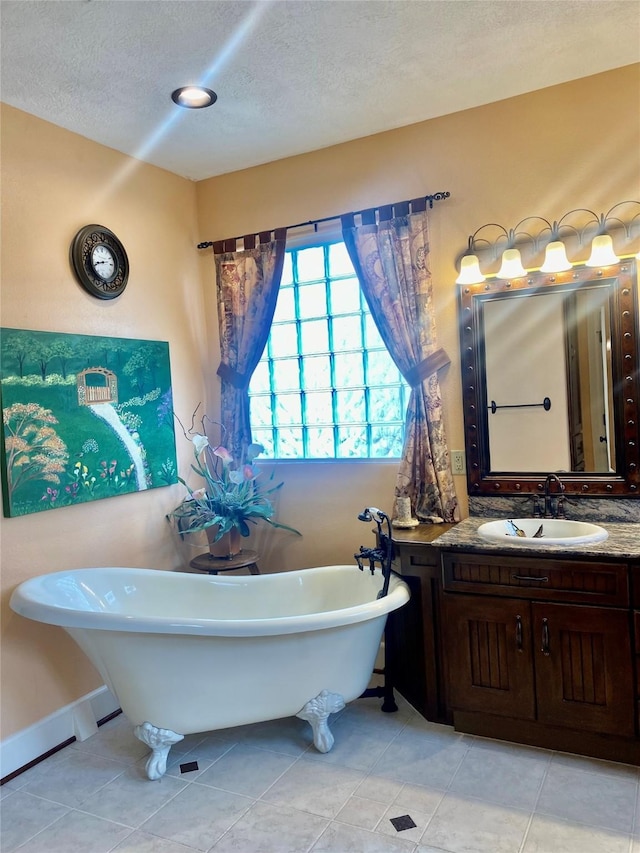 bathroom featuring vanity, tile patterned floors, a tub, and a textured ceiling