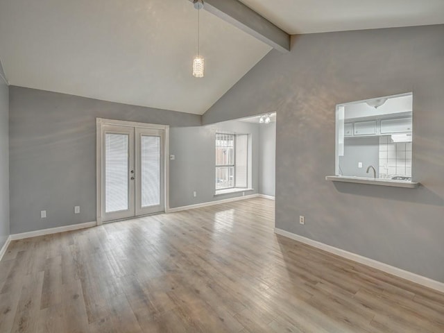 empty room with french doors, sink, high vaulted ceiling, beam ceiling, and light hardwood / wood-style floors