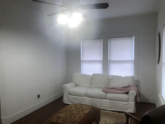 living room featuring dark wood-type flooring and ceiling fan