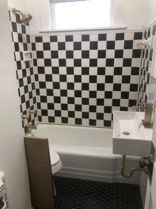 full bathroom with sink, tiled shower / bath, and toilet