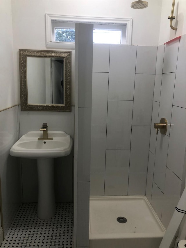 bathroom with a tile shower and tile patterned floors