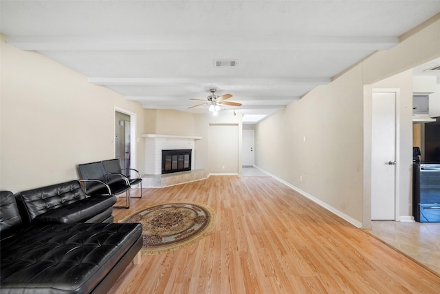 living room featuring beam ceiling, wood-type flooring, and ceiling fan