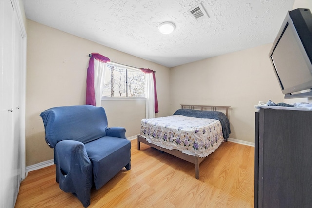 bedroom featuring a textured ceiling and light wood-type flooring