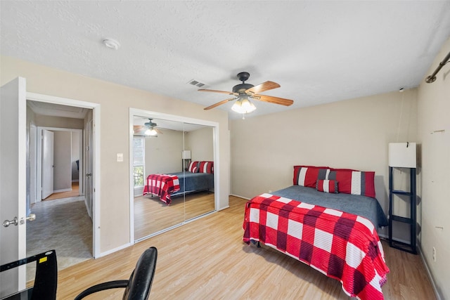 bedroom featuring hardwood / wood-style flooring, a textured ceiling, a closet, and ceiling fan