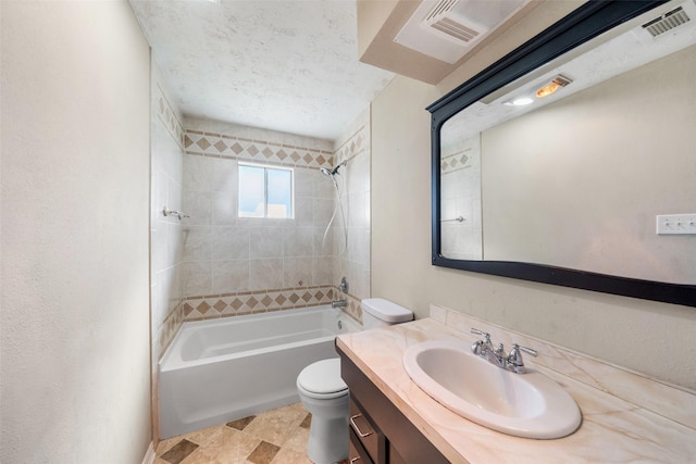 full bathroom with vanity, toilet, tiled shower / bath combo, and a textured ceiling