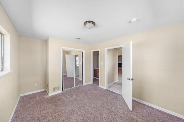 unfurnished bedroom featuring a closet and light carpet