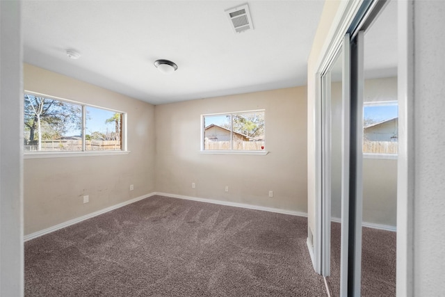 unfurnished room featuring carpet flooring and a wealth of natural light