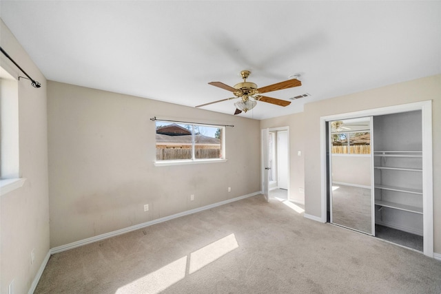 unfurnished bedroom featuring ceiling fan, a closet, and light carpet