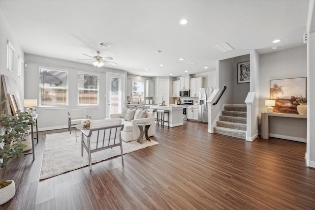 living room featuring dark hardwood / wood-style floors and ceiling fan