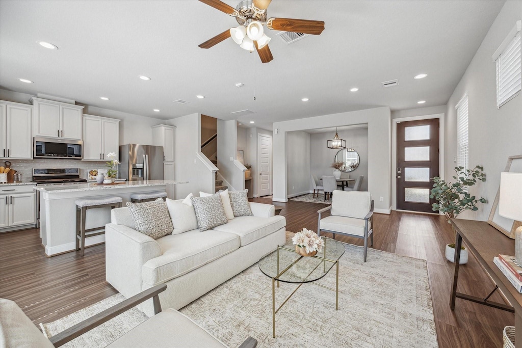 living room featuring wood-type flooring and ceiling fan