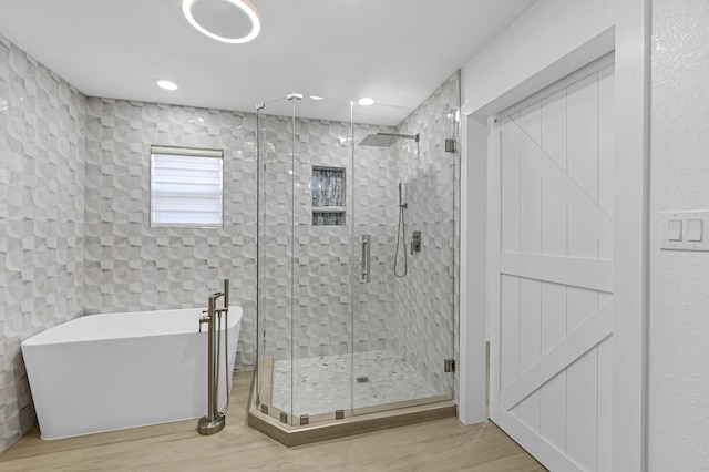 bathroom with hardwood / wood-style floors and independent shower and bath