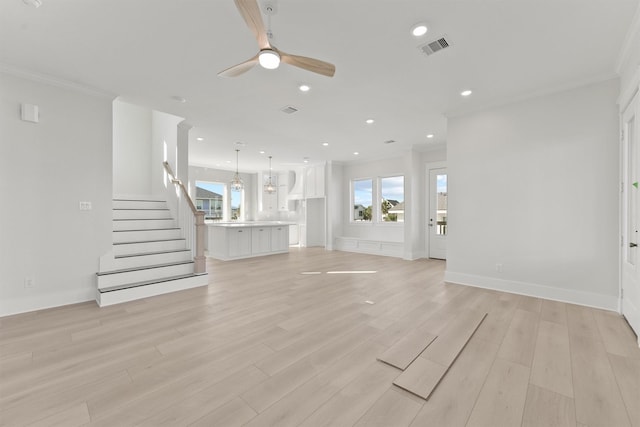 23015 Lunes, Galveston, TX 77554 - unfurnished living room featuring crown molding, light wood-style floors, recessed lighting, a ceiling fan, and stairs