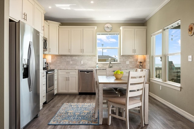 kitchen with tasteful backsplash, white cabinetry, appliances with stainless steel finishes, and ornamental molding